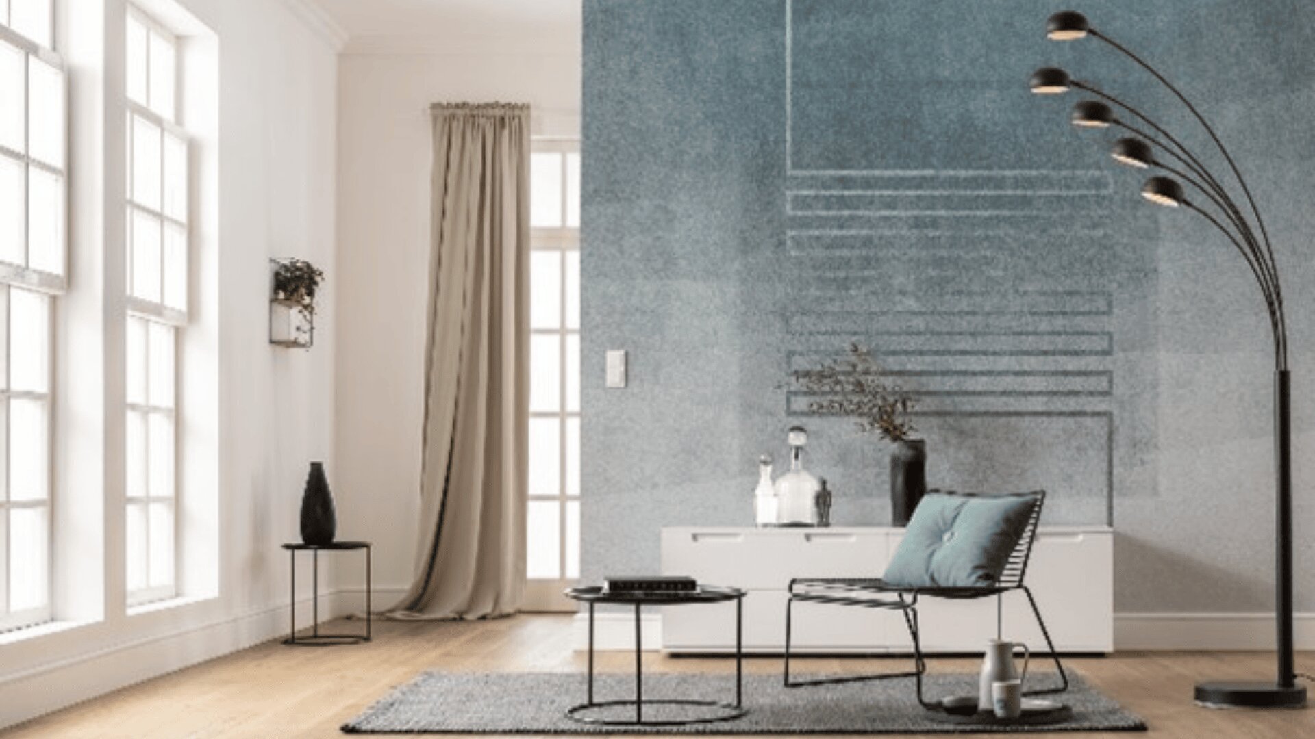 Ein modernes Wohnzimmer mit großen Fenstern, hellen Wänden, einer blauen Akzentwand, minimalistischen Möbeln, einer geschwungenen Stehlampe, einem kleinen Tisch, einer weißen Konsole, dekorativen Vasen und einem grauen Teppich auf Holzboden.