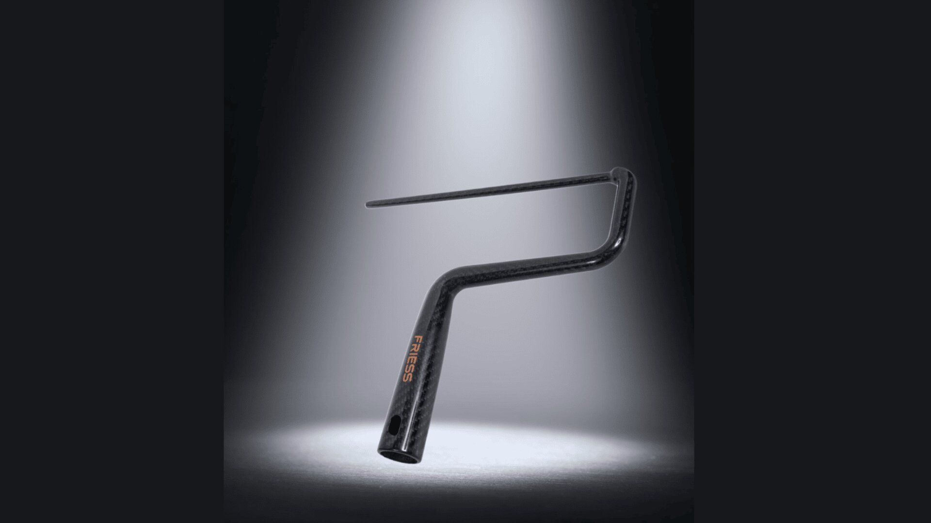Ein schlanker, moderner Fahrradlenker mit integriertem Vorbau wird aufrecht auf einer Bühne mit Scheinwerfern präsentiert und hebt sein schwarzes Carbonfaserdesign und das FIRESS-Logo in Orange hervor.