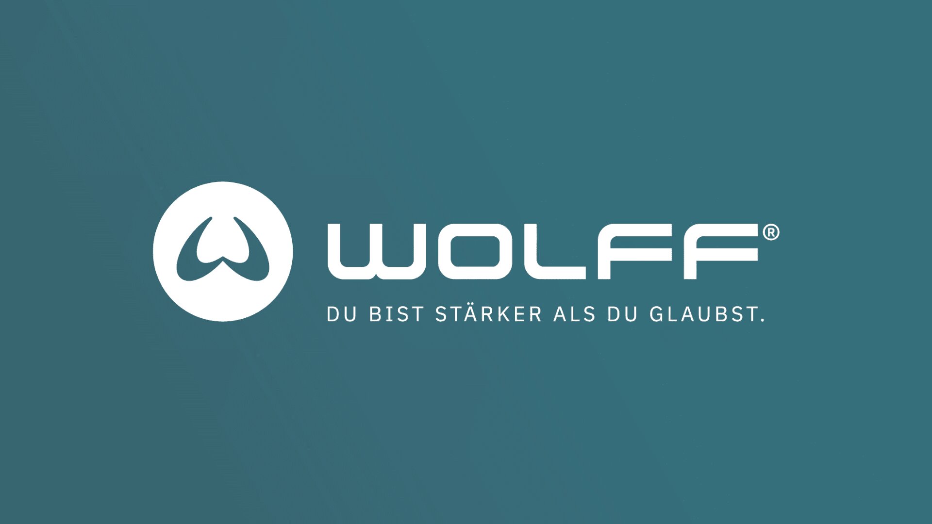 Ein blaugrüner Hintergrund mit einem weißen, runden Logo, das einer stilisierten Wolfspfote ähnelt, daneben das Wort WOLFF in fetten, modernen Buchstaben. Darunter steht der deutsche Satz „DU BIST STÄRKER ALS DU GLAUBST“.