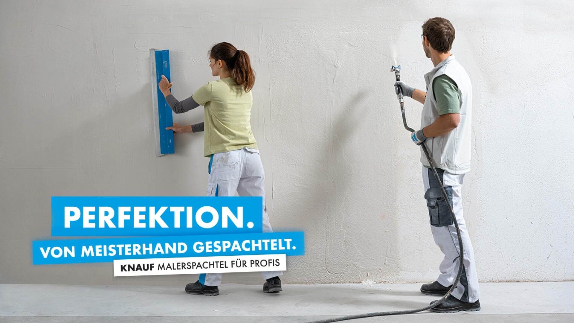 Zwei Personen arbeiten an einer großen weißen Wand; Einer verwendet eine blaue Kelle, der andere eine Spritzpistole. Text auf Deutsch lautet: Perfektion. Von Meisterhand gespachtelt. Knauf Malerspachtel für Profis.