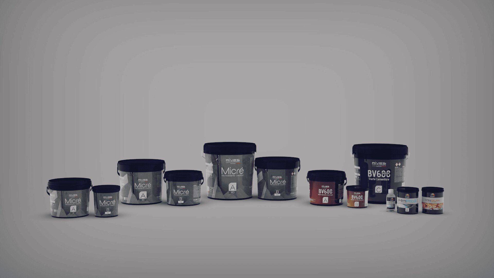 A row of black, gray, and white plastic containers with labels, displayed against a plain gray background. The containers vary in size and have different colored labels, including black, gray, red, and blue.