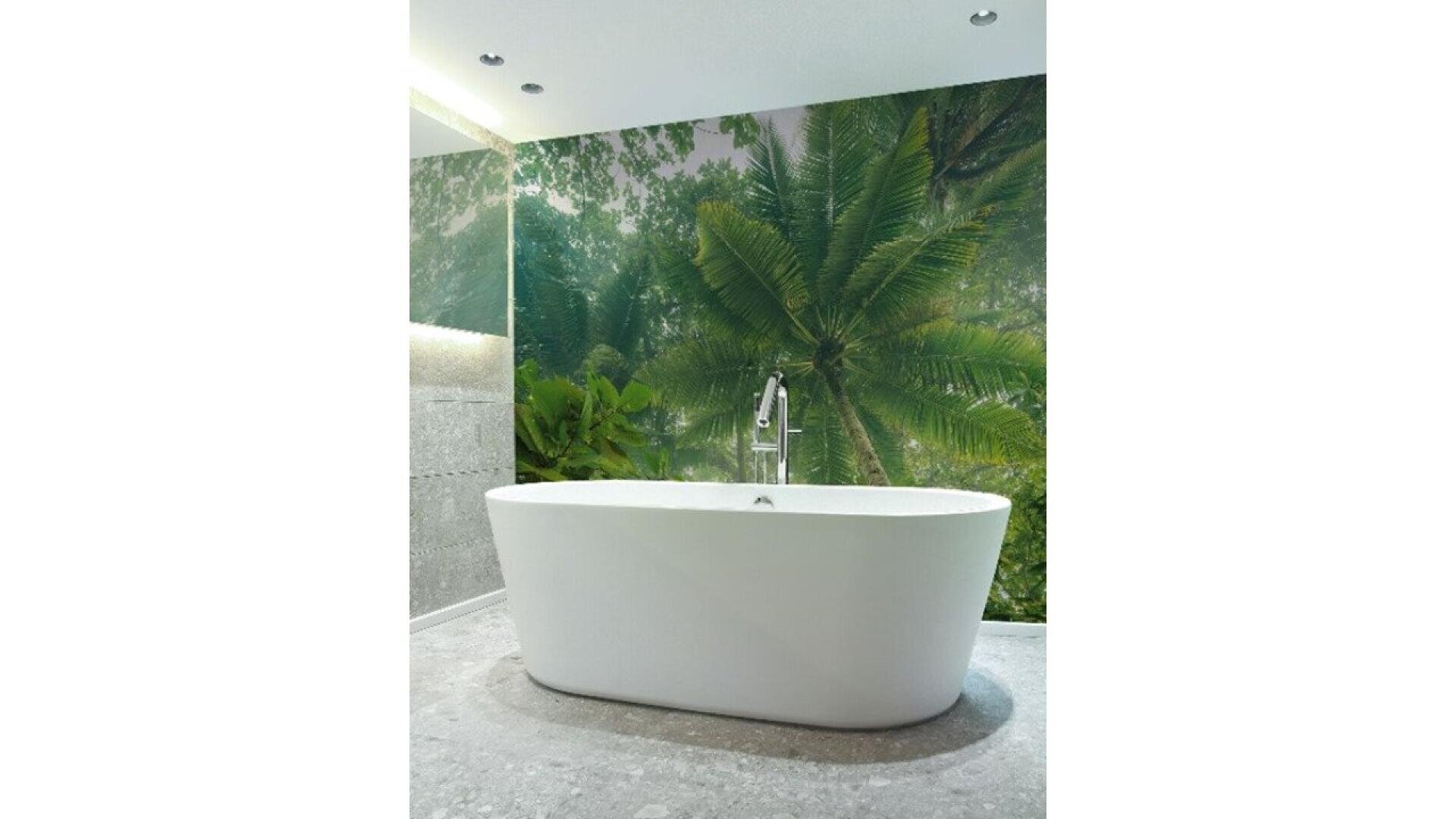 A modern white bathtub sits in a minimalist bathroom with gray stone flooring and a large wall mural of tropical palm trees and lush greenery behind it.