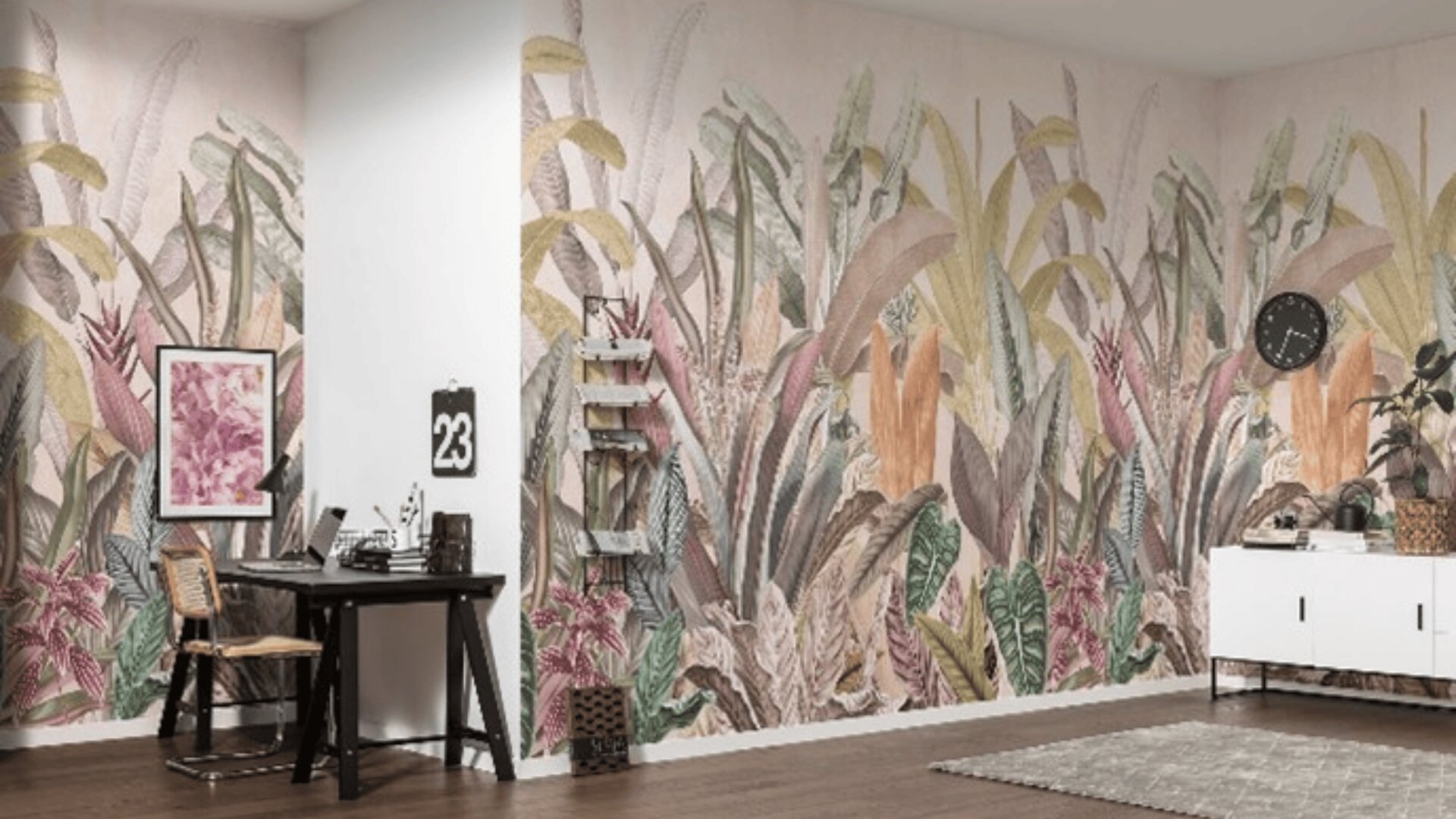 Ein modernes Arbeits- und Wohnzimmer mit einem großen botanischen Wandbild, das zwei Wände bedeckt, einem schwarzen Schreibtisch mit Rattanstuhl, schwebenden Regalen, einem weißen Schrank und Holzfußboden.