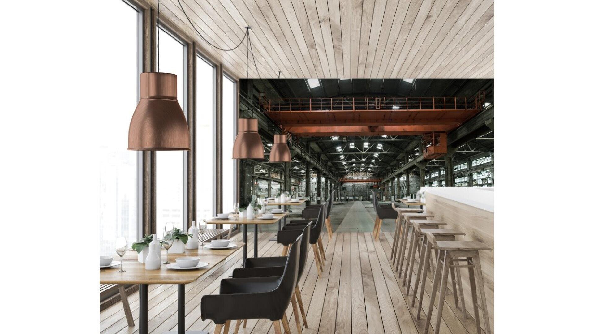 Modern restaurant interior with wooden floors and ceiling, black chairs at tables, barstools at a counter, pendant lights, and large windows overlooking an industrial factory space with metal beams and equipment.