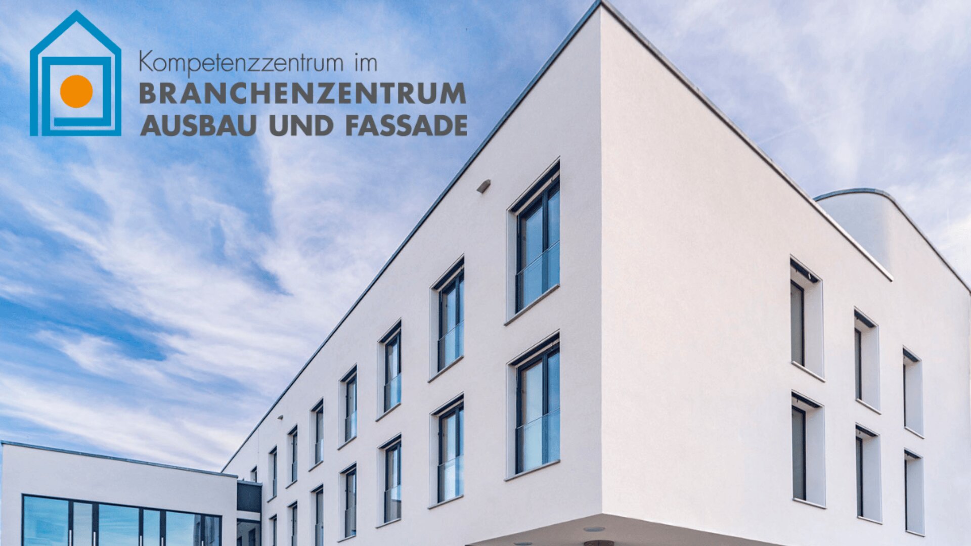 Modernes weißes Gebäude mit großen Fenstern unter einem blauen Himmel. In der oberen linken Ecke befindet sich ein Logo und ein deutscher Text: Kompetenzzentrum im Branchenzentrum Ausbau und Fassade.